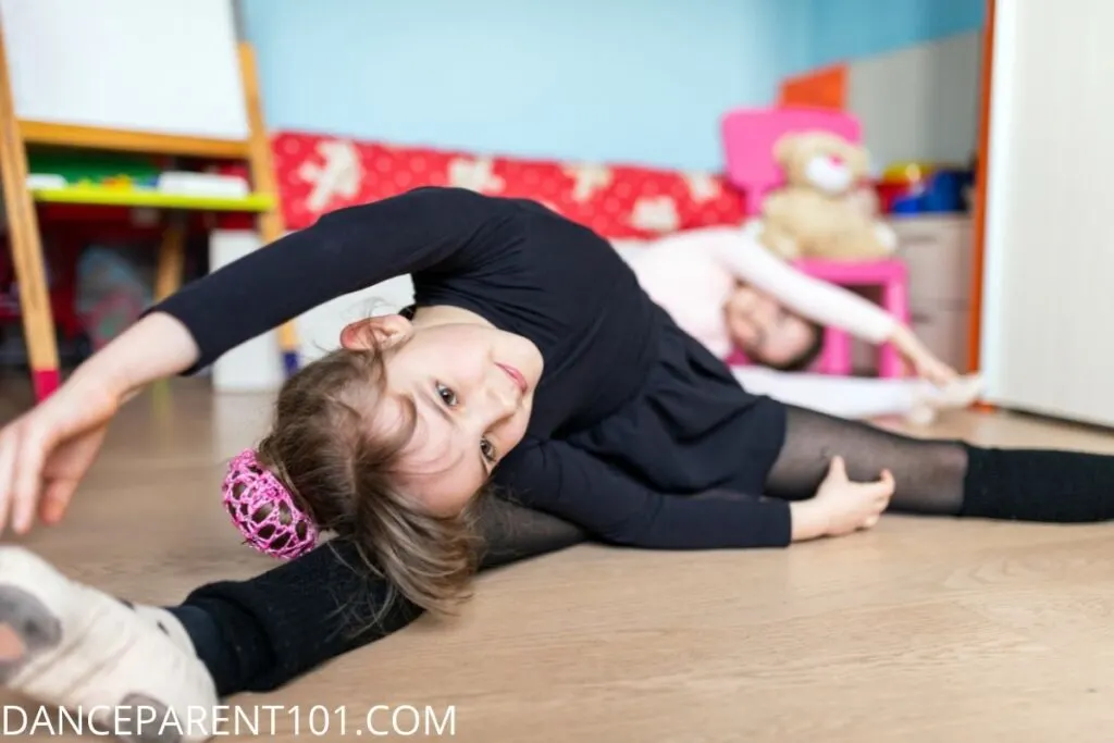 Girl stretching in middle splits in her bedroom