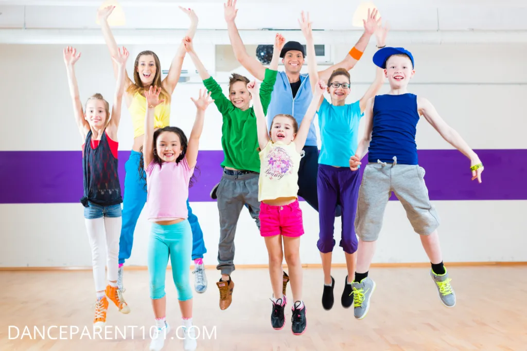 Kids of different ages jumping for joy in a hip hop class -  - What to Expect From Your Child's First Hip Hop Dance Class