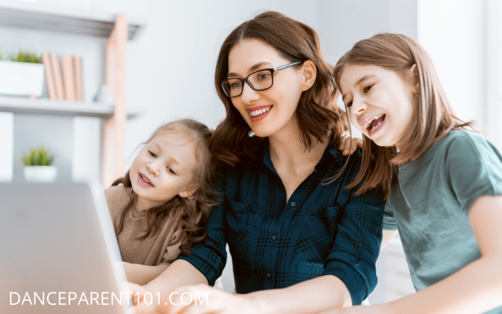 Mother with daughters looking at a laptop - How to Choose the Best Dance School For Your Child: Guide For New Dance Parents 