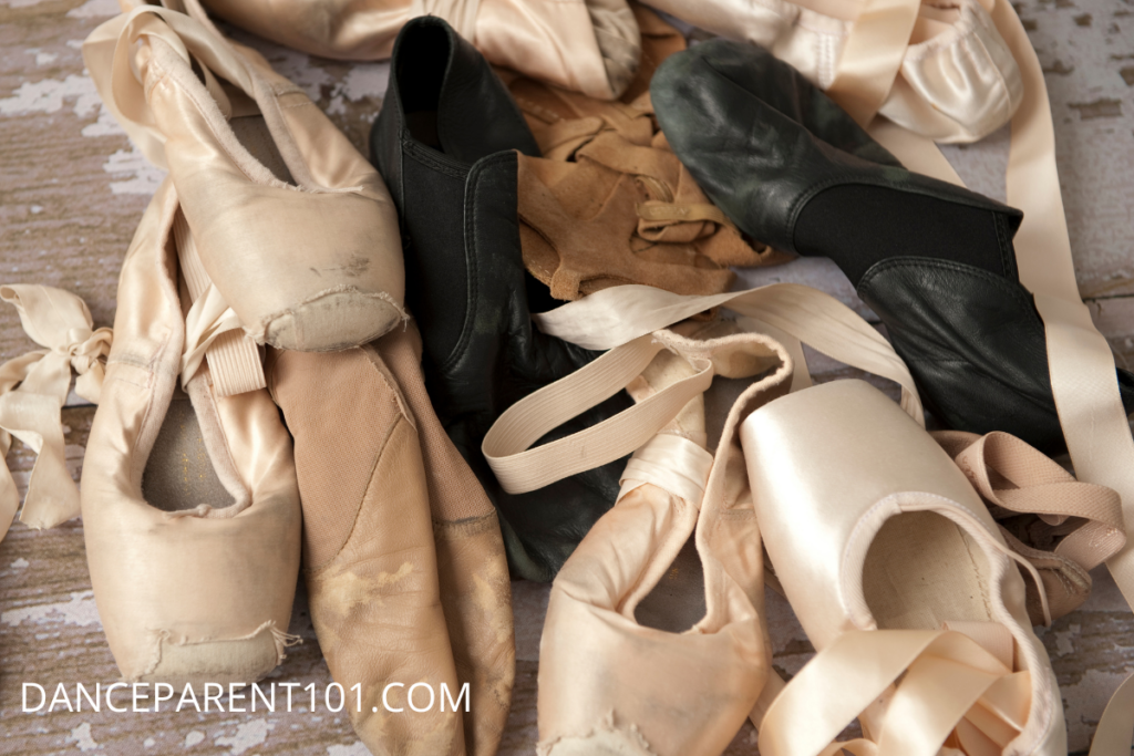 A pile of used dance shoes, including pointe shoes, jazz shoes, and lyrical sandals