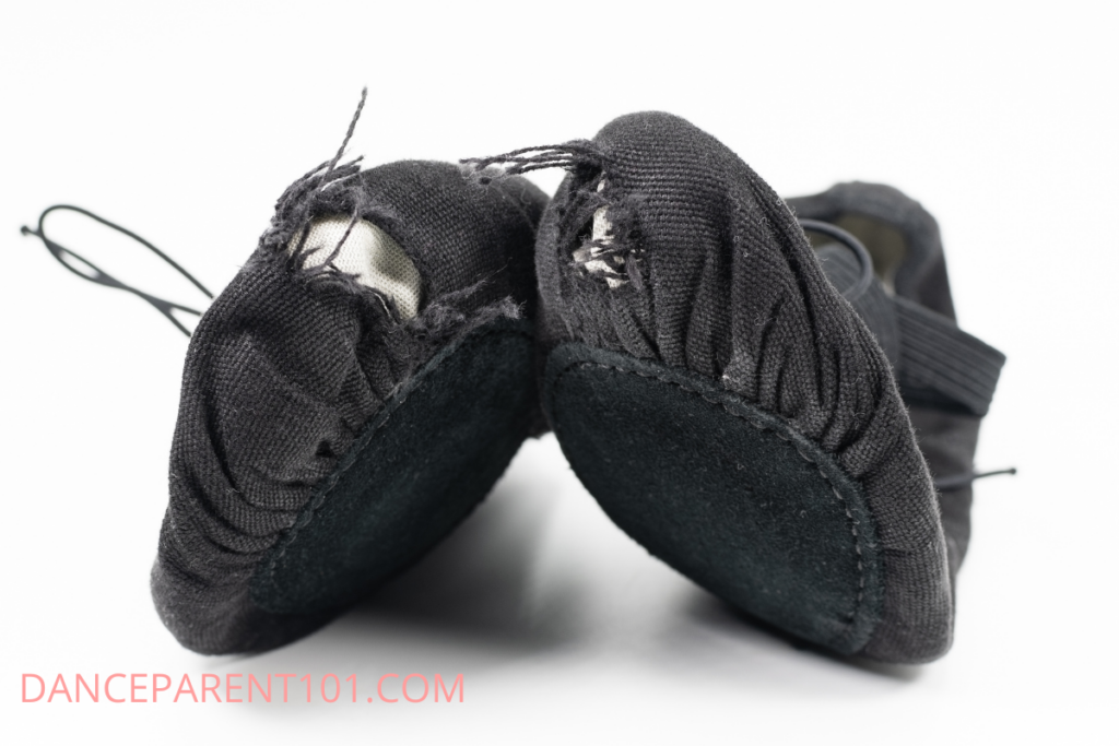Black canvas ballet shoes with holes in the toes
